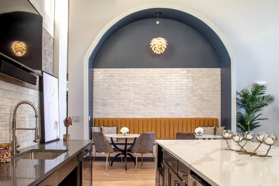 An apartment clubhouse like this one at Verge Luxury Flats is a nice workspace alternative for remote work. An apartment clubhouse with stylish kitchenette and seating