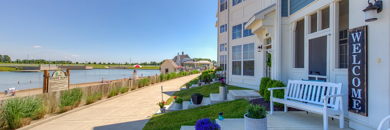 Potted plants on the outdoor steps of an apartment and a beachfront view