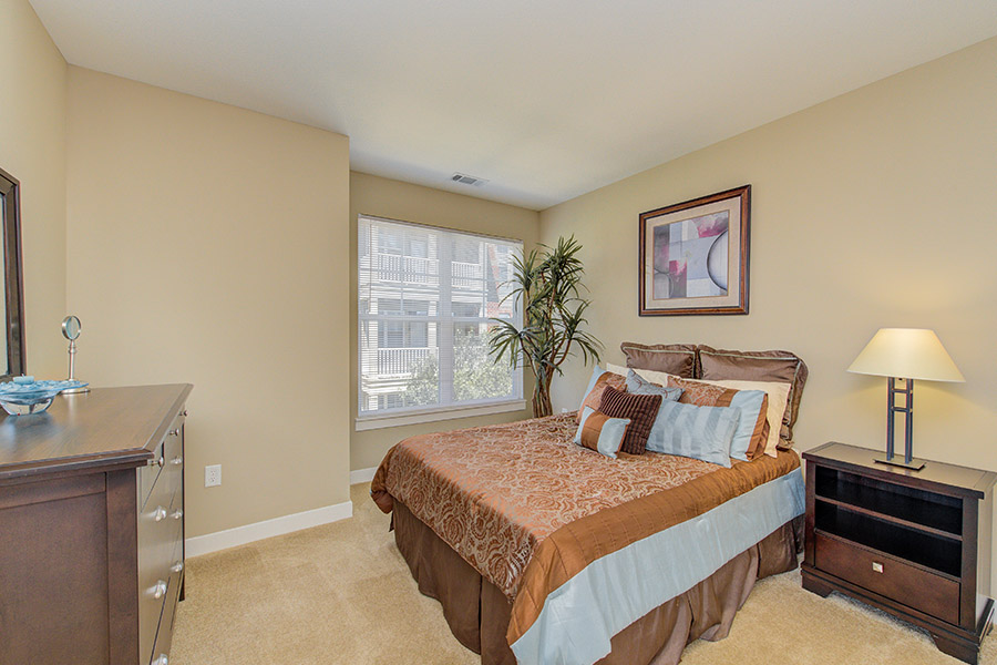 When hanging frames like the one in this bedroom at The District at Saxony Apartment Homes, use the right tools to avoid damage. Stylish apartment bedroom in neutral tones