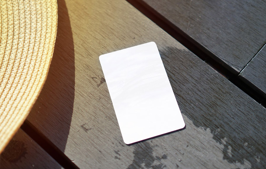 Don't forget your pool pass to to take a refreshing swim at Bayshore Apartments. Summer hat and key card on a deck floor.