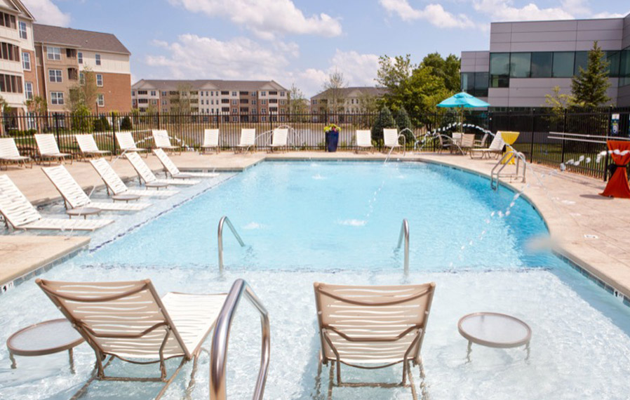 A beautiful blue pool enhances your apartment experience in Greenwood. Lake side pool on a sunny day.